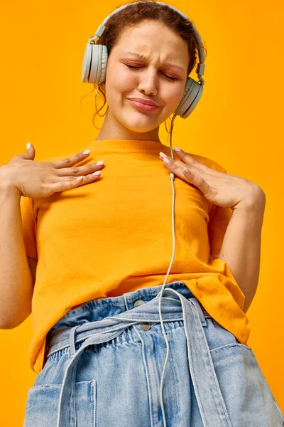 Pretty girl yellow t-shirt headphones entertainment music fun isolated backgrounds unaltered — Φωτογραφία Αρχείου