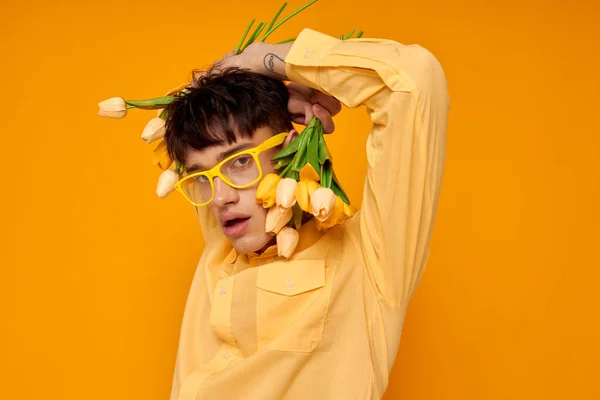 Foto de novio joven romántico con un peinado de moda en camisas amarillas con flores fondo amarillo inalterado — Foto de Stock