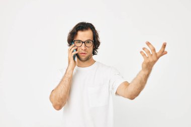 Beyaz tişörtlü yakışıklı adam telefon ışığı arkaplanından iletişim kuruyor.