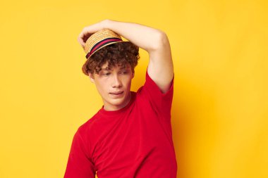 Sevimli kızıl saçlı adam duygular kırmızı tişört şapka stüdyo sarı arka plan değiştirilmemiş