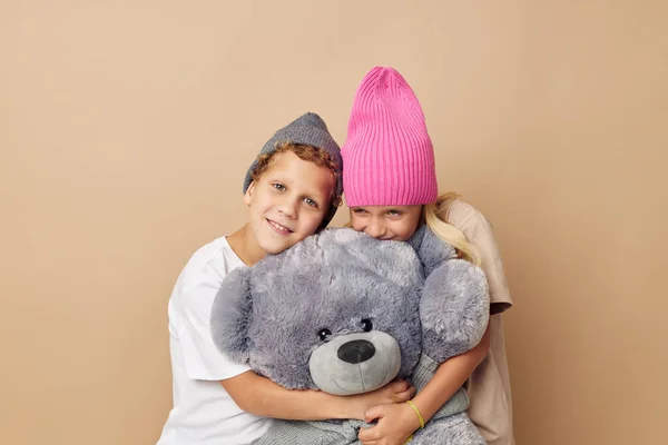 Photo of two children in hats with a teddy bear friendship Lifestyle unaltered — 图库照片