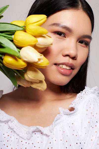 Žena s asijským vzhledem květiny jaro pózování světlo pozadí beze změny — Stock fotografie