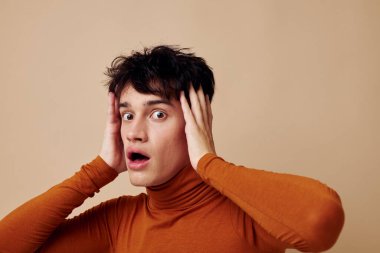 Yakışıklı adam kahverengi balıkçı yaka. Moda arkaplan pozu veriyor.