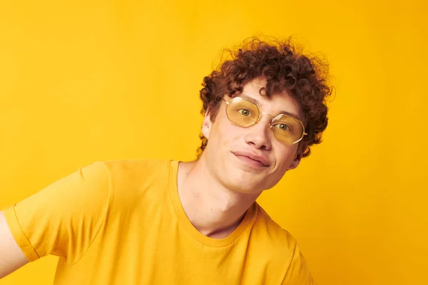 Retrato de um jovem encaracolado óculos estilo jovem estúdio casual desgaste amarelo fundo inalterado — Fotografia de Stock