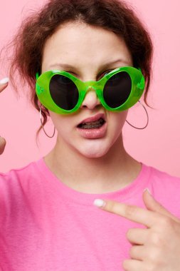 çekici genç kadın moda yeşil gözlükleri pembe tişört dekorasyonu poz