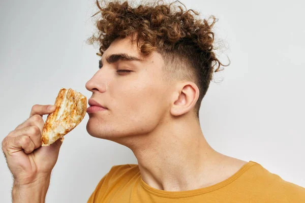 Привабливий чоловік їсть піцу, позує крупним планом Стиль життя незмінний — стокове фото