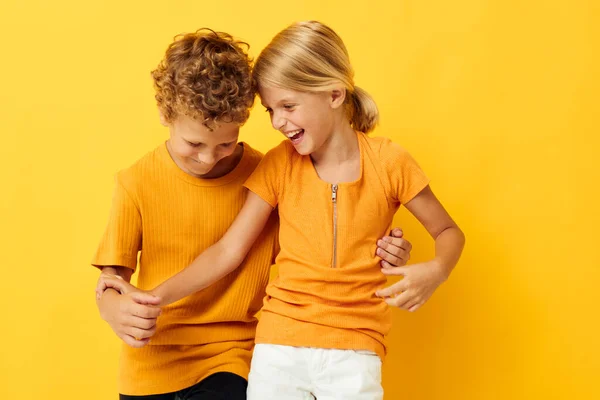 Портрет милых детей обнимая моду детство развлечения желтый фон без изменений — стоковое фото