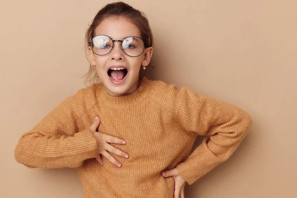 Schattig meisje in een trui en poseren bril geïsoleerde achtergrond — Stockfoto