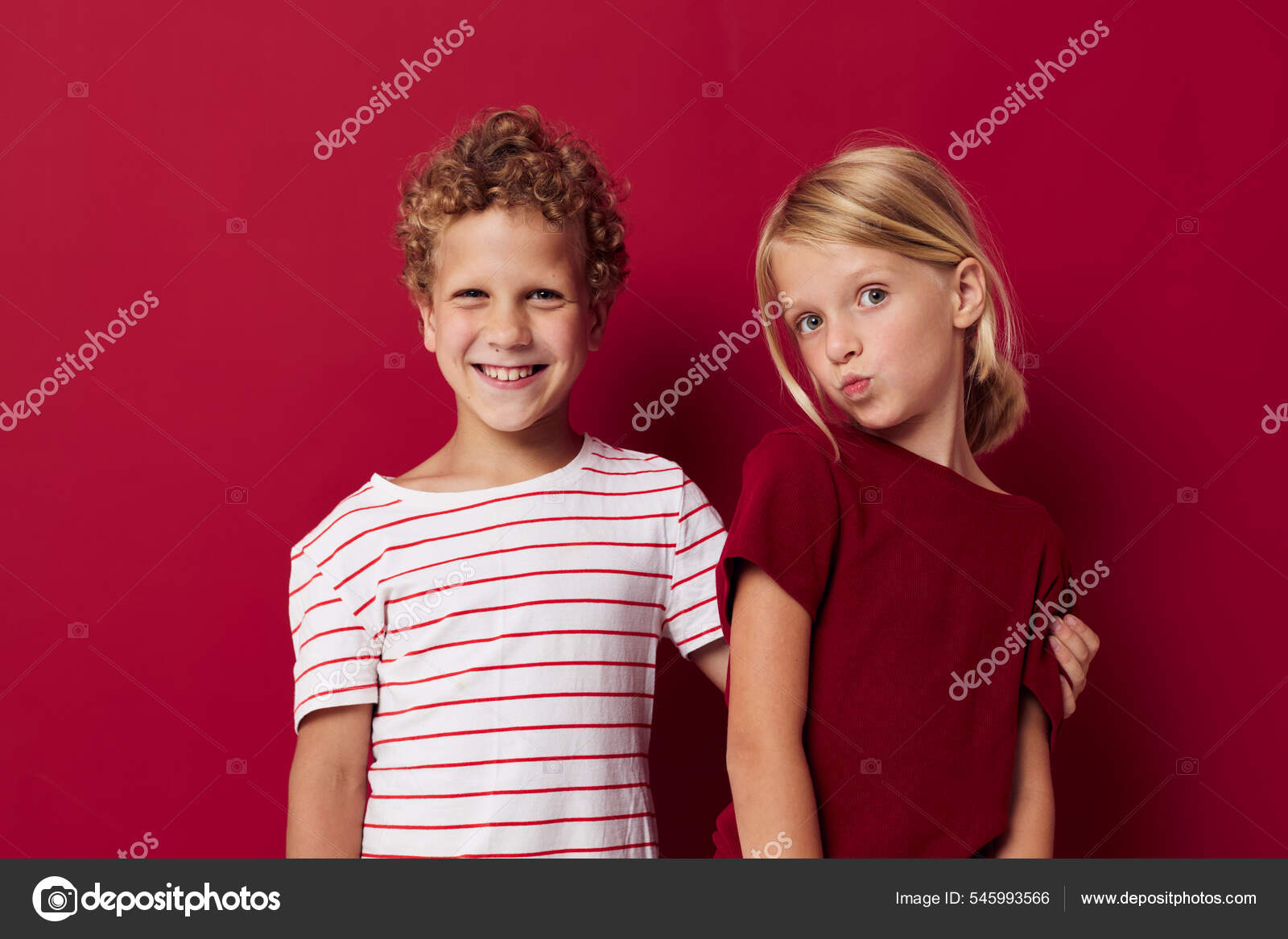 Boy and girl smiling and posing in casual clothes against on