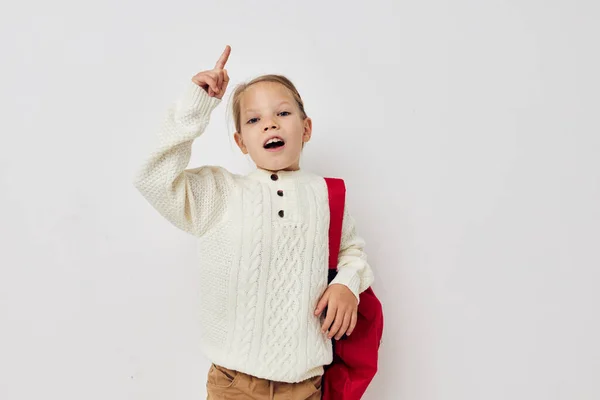 Portret van vrolijk lachend kind meisje rode rugzak stijlvolle kleding lichte achtergrond — Stockfoto