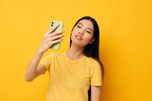 Donna con un telefono in mano fa un modello di studio selfie inalterato — Foto Stock
