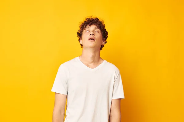 Tipo de pelo rojo rizado en una camiseta blanca sobre un fondo amarillo — Foto de Stock