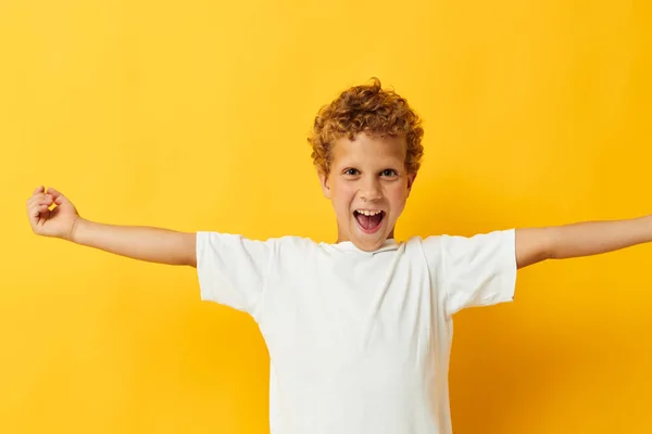 Veselý chlapec v bílém tričku pózující žluté pozadí dětství — Stock fotografie