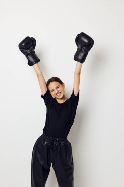 Siyah pantolonlu, boks eldivenli ve spor tişörtlü güzel bir kız.