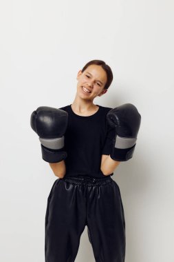 Siyah pantolonlu, boks eldivenli ve spor tişörtlü güzel bir kız.