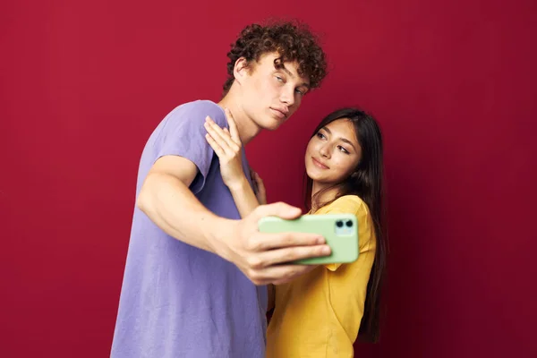 Una giovane coppia stile moderno emozioni divertimento telefono isolato sfondo — Foto Stock