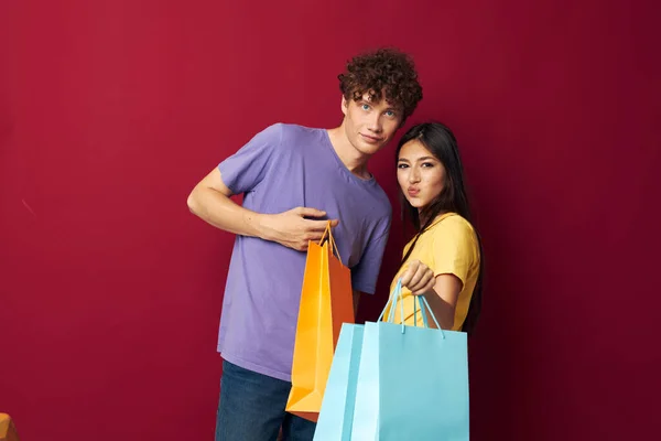 Jong jongen en meisje winkelen tassen in de hand geïsoleerde achtergrond ongewijzigd — Stockfoto