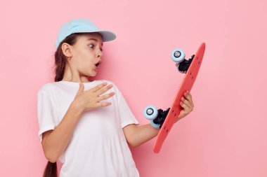 Çocukluğunda elinde kaykayla gülümseyen mutlu çocuk portresi.