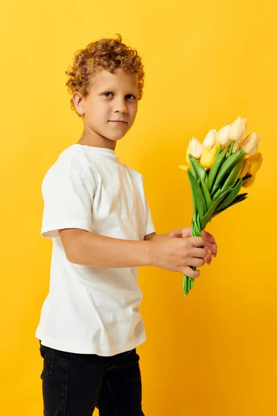 Photo portrait curly little boy with yellow flowers posing childhood fun color background unaltered — Stock Photo, Image