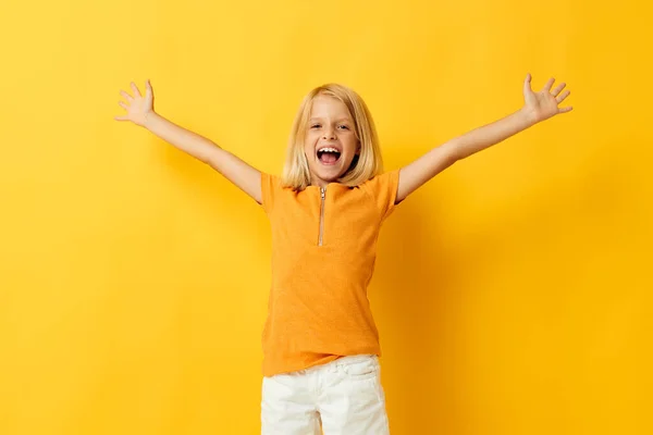 Молодая блондинка в жёлтой футболке улыбается, позируя студийному образу жизни детства без изменений — стоковое фото