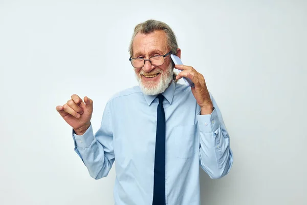 Senior homme aux cheveux gris dans une chemise avec une cravate avec une technologie de téléphone vue recadrée — Photo