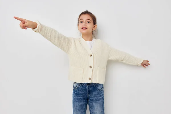 Bambina in posa in un maglione bianco infanzia inalterata — Foto Stock