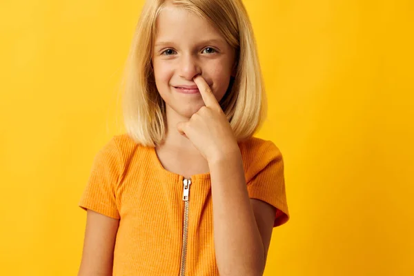Cute little girl with blond hair based childhood yellow background — Stockfoto