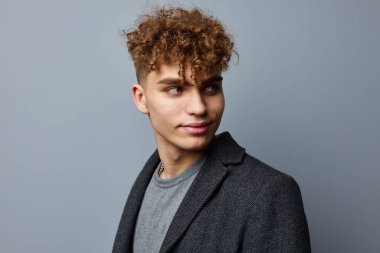 Ceketli çekici bir adam. Kareli bir eşarp. Yaşam tarzı değişmemiş.