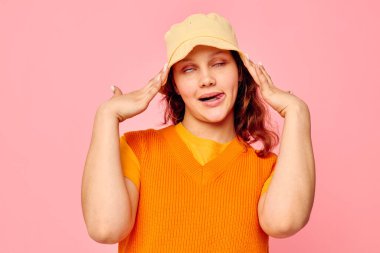 Komik kız, ekşi küpeler. Şapka takıyor. Arka planda bir değişiklik yok.