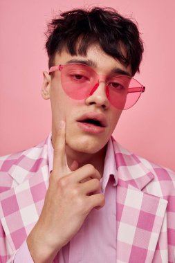 Yakışıklı adam pembe gözlüklü, kareli ceket modasında. Yaşam tarzını değiştirmemiş.