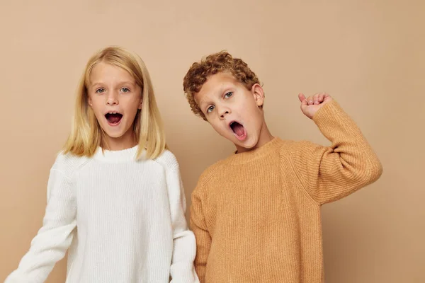 Portret van leuke kinderen knuffel entertainment poseren vriendschap beige achtergrond — Stockfoto