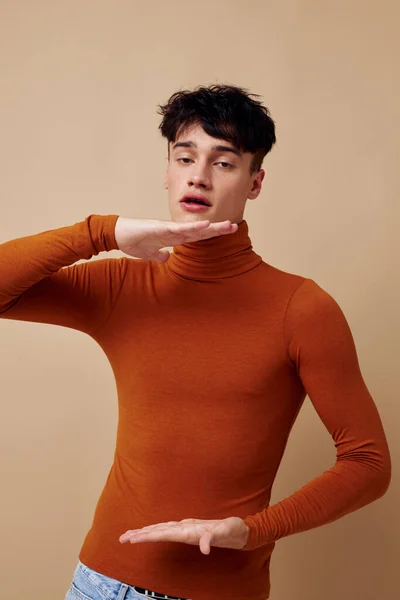 Retrato de un joven posando en suéter marrón confianza en sí mismo moda luz fondo inalterado —  Fotos de Stock