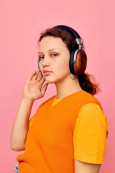 Bela mulher fones de ouvido música moda posando rosa fundo inalterado — Fotografia de Stock