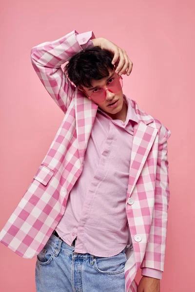Chico guapo moda rosa gafas de sol chaqueta posando fondo rosa inalterado — Foto de Stock