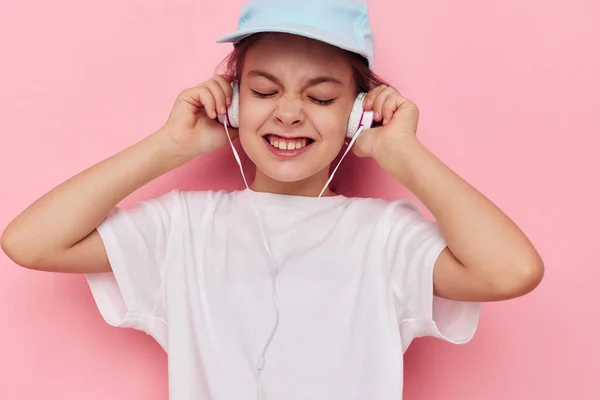 Little girl listening to music on headphones isolated background — Stock Photo, Image