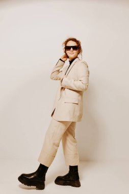 Güneş gözlüğü takmış güzel bir kadın ellerini hareket ettirir. Duyguları değişmez.