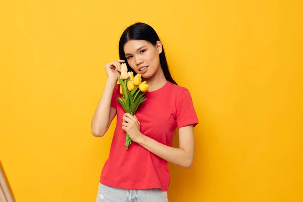 Söt asiatisk flicka i röd t-shirt med en bukett blommor — Stockfoto