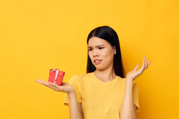 Donna con aspetto asiatico in possesso di una scatola regalo nelle sue mani posa sfondo isolato inalterato — Foto Stock