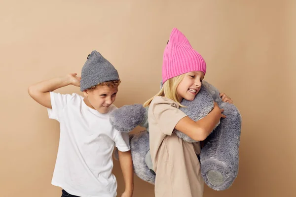 Мальчик и девочка в шляпах с плюшевым мишкой дружба образ жизни неизменен — стоковое фото