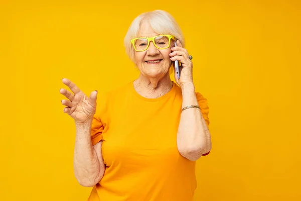 Улыбающаяся пожилая женщина весело говорить по телефону изолированный фон — стоковое фото