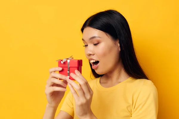 Affascinante giovane donna asiatica Piccola scatola regalo rossa divertente sfondo giallo inalterato — Foto Stock