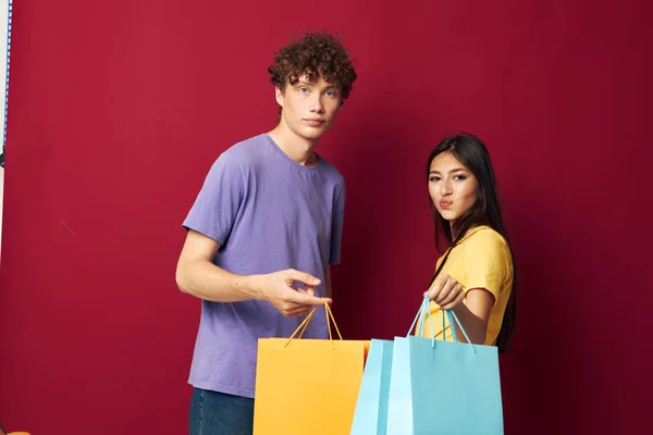 Schattig jong stel winkelen tassen in de hand geïsoleerde achtergrond ongewijzigd — Stockfoto