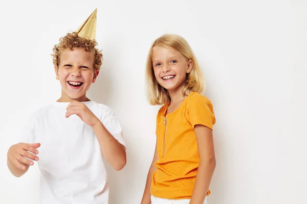 Aranyos elegáns gyerekek pózol érzelmek ünnep színes sapkák elszigetelt háttér változatlan — Stock Fotó