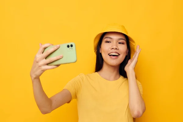 Donna con aspetto asiatico in possesso di un telefono posa stile di vita tecnologia isolato sfondo inalterato — Foto Stock