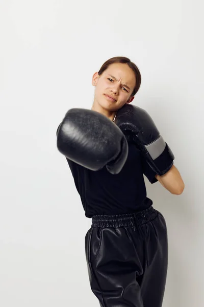 Jong mooi vrouw in zwart sport uniform bokshandschoenen poseren geïsoleerde achtergrond — Stockfoto