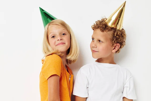 Vrolijk kinderen in veelkleurige caps verjaardag vakantie emotie geïsoleerde achtergrond ongewijzigd — Stockfoto