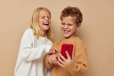 Kırmızı telefonu olan küçük bir çocuk ve kız. Teknolojiler izole edilmiş arka plan.