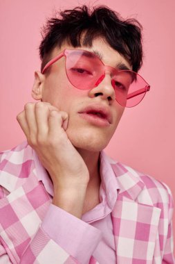 Yakışıklı adam pembe gözlüklü, kareli ceket modasında. Yaşam tarzını değiştirmemiş.