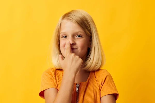 Cheerful little girl hand gesture and fun yellow background — Stockfoto