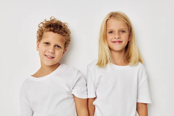 Маленькие мальчик и девочка в белых футболках стоят рядом с образом жизни без изменений — стоковое фото